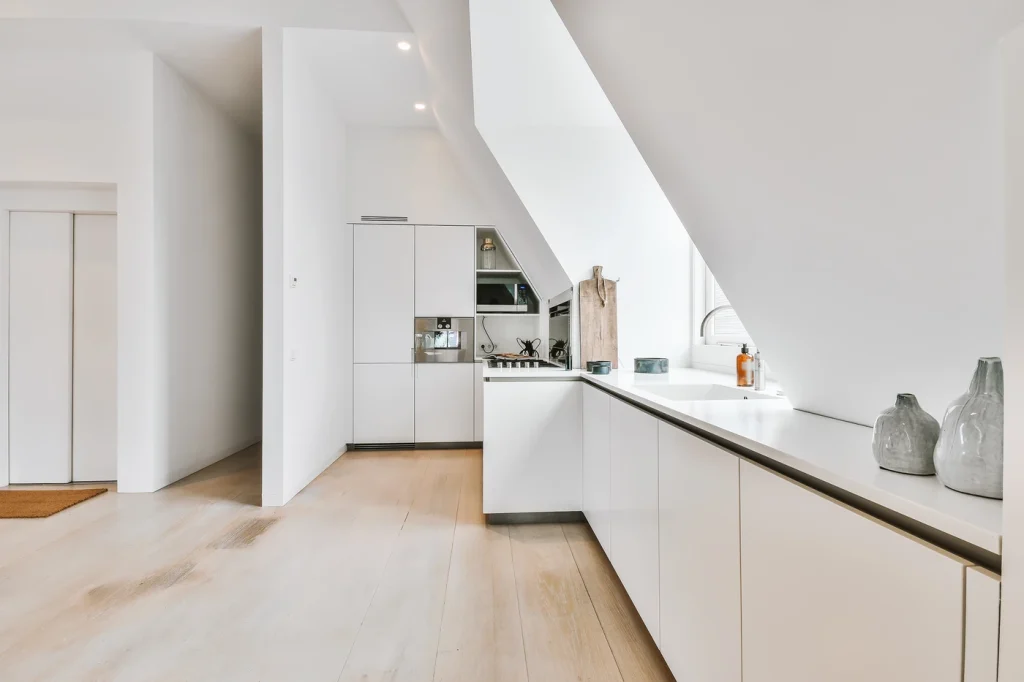 Cocina blanca con muebles brillantes y suelo negro